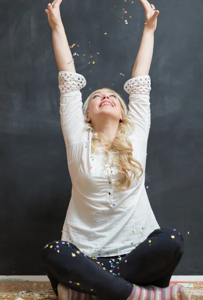 Cheerful young woman is stretching out her hands while confetti — Stock Photo, Image