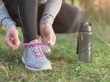 Koşu ayakkabıları - kadın ayakkabı bağcıklarımı bağlıyor. Kadın spor closeup 