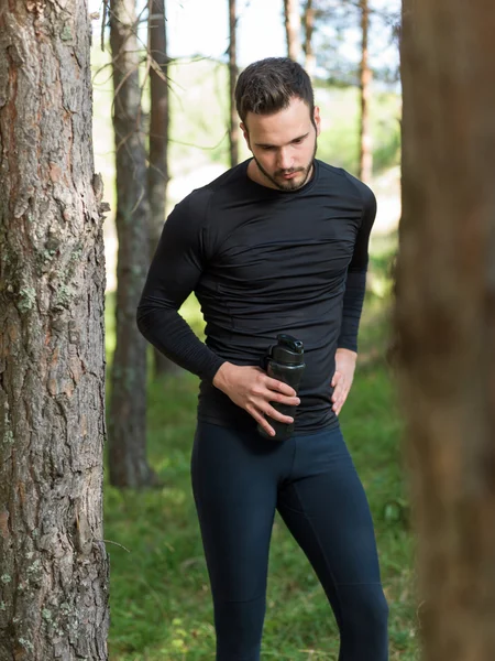 Man drinking water after sport in a park — Stok fotoğraf