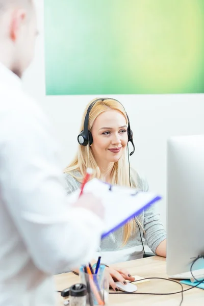 Affärskvinna prata i telefon medan du arbetar på hennes dator — Stockfoto
