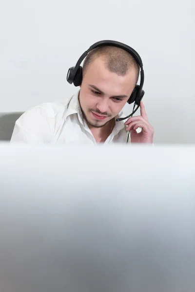 Asistente sonriente con auriculares en un call center —  Fotos de Stock