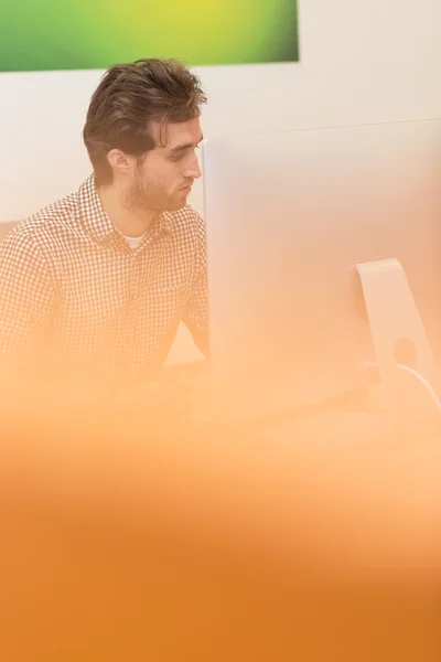 Чоловік дивиться на екран комп'ютера, думаючи про роботу під рукою — стокове фото