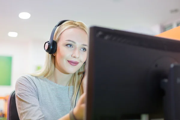 Retrato de uma jovem mulher de negócios usando computador no escritório — Fotografia de Stock