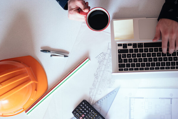 Architect working on blueprint. Architects workplace - architect