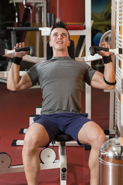 Atleta joven levantando pesas en el gimnasio — Foto de Stock