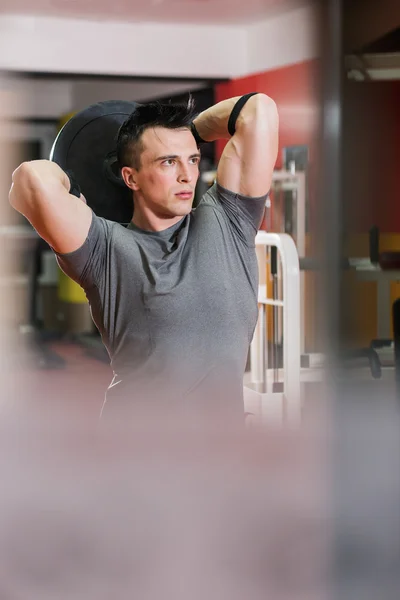 Gimnasio: chico en un gimnasio haciendo levantamiento de pesas — Foto de Stock