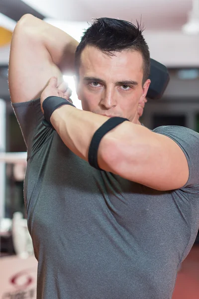 Health club: cara em um ginásio fazendo levantamento de peso — Fotografia de Stock