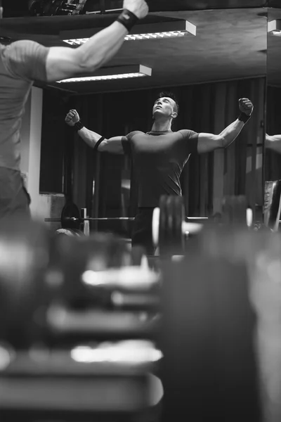 Schöner Mann im Fitnessstudio, der schwere Freigewichte stemmt — Stockfoto