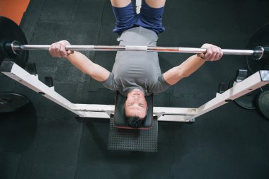 Spor salonunda egzersiz göğüs Bench Press - üstten görünüm üzerinde genç adam