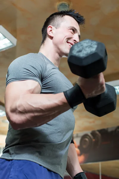 Pazı - dumbbell konsantrasyon bukleler çalışan genç adam — Stok fotoğraf