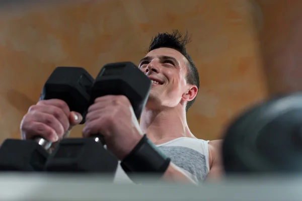Homem muscular feliz exercitando com halteres — Fotografia de Stock