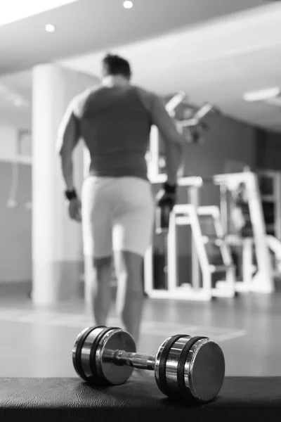 Big dumbbells with active body builder in background — Stock Photo, Image