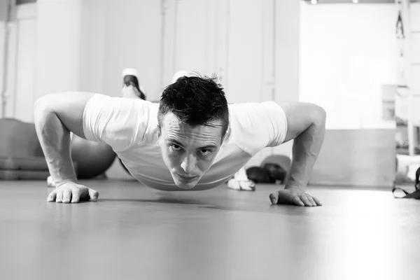 Um homem musculoso fazendo flexões no ginásio crossfit — Fotografia de Stock