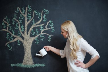 Çizim tebeşir para ağacı önünde mutlu sarışın iş kadını