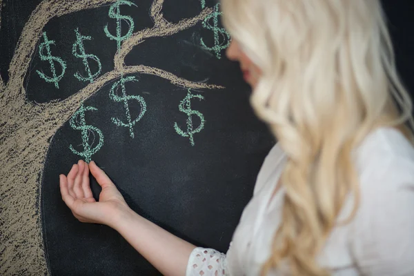 Щаслива блондинка бізнес-леді перед крейдяним малюванням грошей на дереві — стокове фото