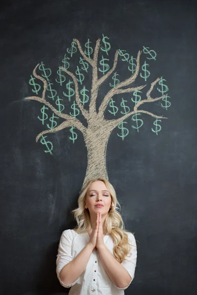 Mujer de negocios rubia feliz delante de tiza árbol de dinero dibujo — Foto de Stock