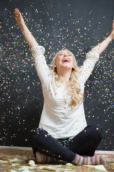 Cheerful young woman is stretching out her hands while confetti — Stock Photo, Image