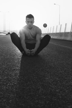 Erkek koşucu germe egzersiz yaparak sabah wor için hazırlanıyor