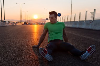runner siyah asfaltta çalıştırdıktan sonra yalan dinleniyor. M koşu