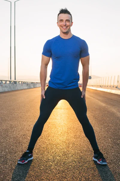 Retrato del corredor masculino en el atardecer de la carretera, piernas esparcidas —  Fotos de Stock