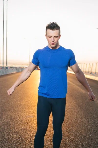 Fitness futó ember napnyugtakor a nap, a hátsó nyújtás — Stock Fotó