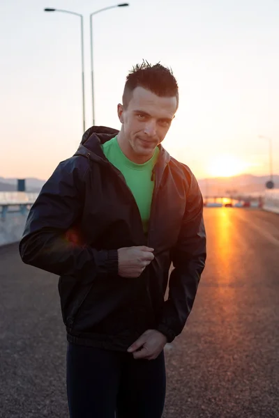 Atlético hombre relajante después de duro trabajo fuera, carretera puesta de sol — Foto de Stock