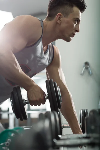 Primo piano di un giovane uomo muscoloso sollevamento pesi, uomo caucasico — Foto Stock