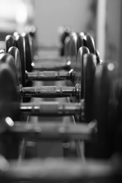 Row of dumbells with lens flare and depth of field effect — Stock Photo, Image