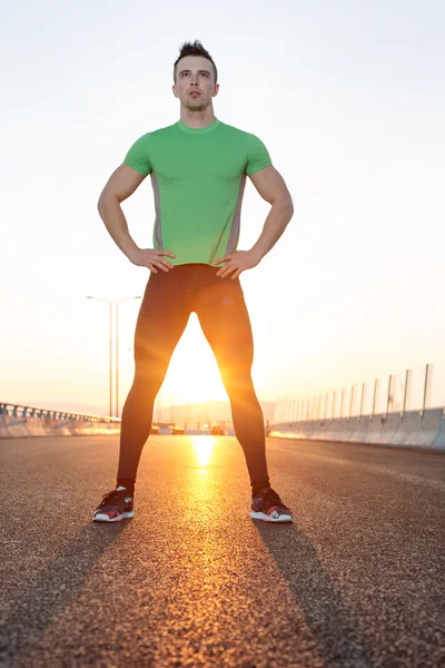 Estiramiento después de correr. tiro al atardecer en carretera — Foto de Stock