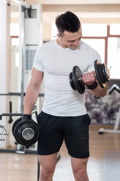 Visar hans stora kropp och hålla dumbell. — Stockfoto