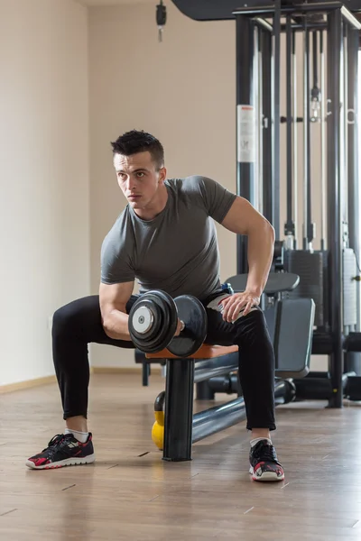 Joven ejercitando bíceps - Dumbbell Concentration Curls — Foto de Stock