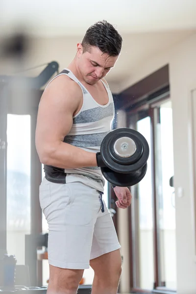 Joven ejercitando bíceps - Dumbbell Concentration Curls — Foto de Stock