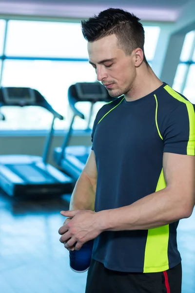 Retrato de un joven físicamente en forma en el moderno gimnasio — Foto de Stock