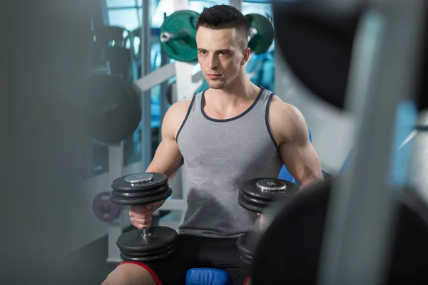 Muscular joven haciendo ejercicio de peso pesado para bíceps con D — Foto de Stock