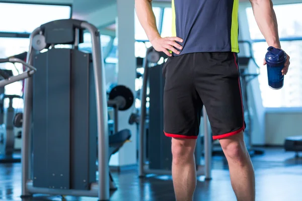 Retrato de un joven físicamente en forma en el moderno gimnasio — Foto de Stock