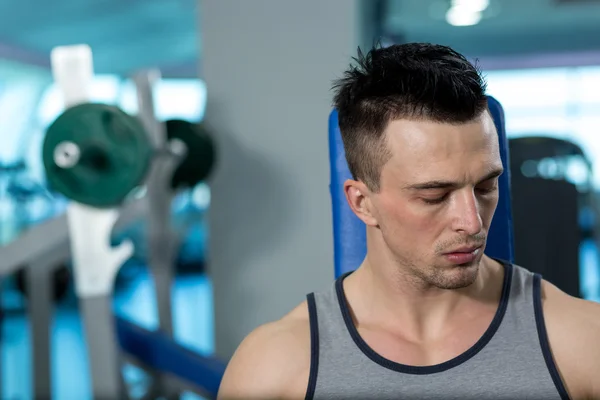 Retrato de un joven físicamente en forma en el moderno gimnasio — Foto de Stock