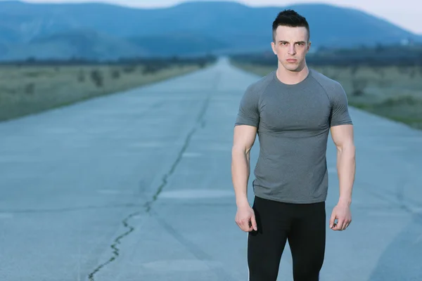 Healthy athlete man jogging at morning on empty roat in the city — Stock Photo, Image