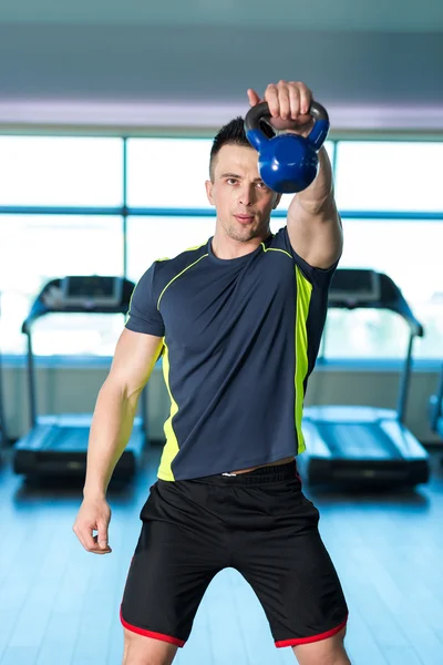 Ejercicio con Kettle Bell. Hombre atlético haciendo ejercicios con blu — Foto de Stock
