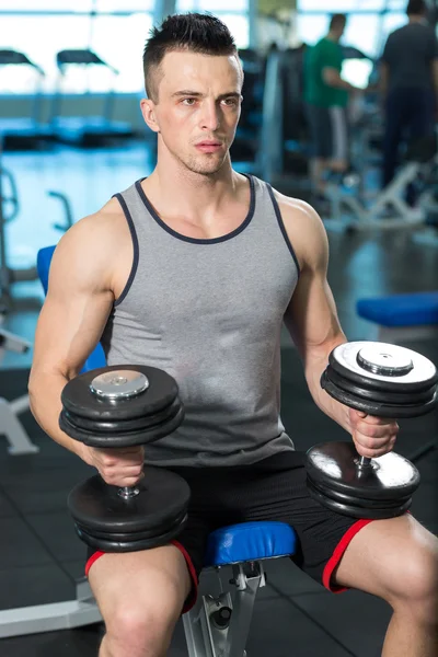 Jovem muscular fazendo exercício de peso pesado para bíceps com D — Fotografia de Stock