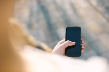 kız ile smartphone Park'ta açık havada. Eller closeup bir