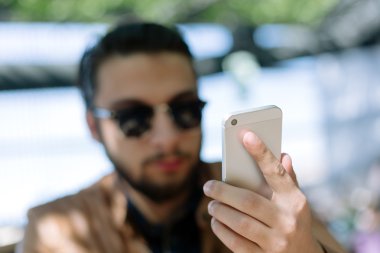 Genç işadamı cep telefonundan sms okuyor smiling