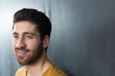 seksi bir adam duvara karşı büyük gülümseyen sakallı