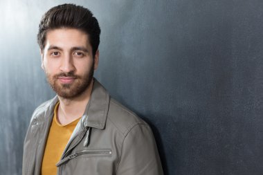 Yakışıklı kendine güvenen genç adam karşı katlanmış kolları ile ayakta