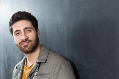 Yakışıklı kendine güvenen genç adam karşı katlanmış kolları ile ayakta