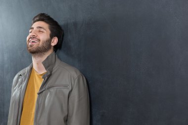 Yakışıklı kendine güvenen genç adam karşı katlanmış kolları ile ayakta