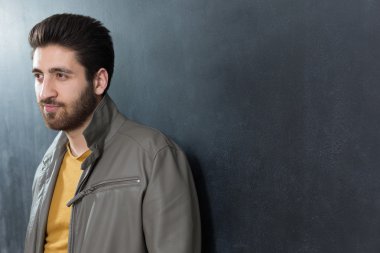 Yakışıklı kendine güvenen genç adam karşı katlanmış kolları ile ayakta