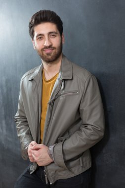 Yakışıklı kendine güvenen genç adam karşı katlanmış kolları ile ayakta