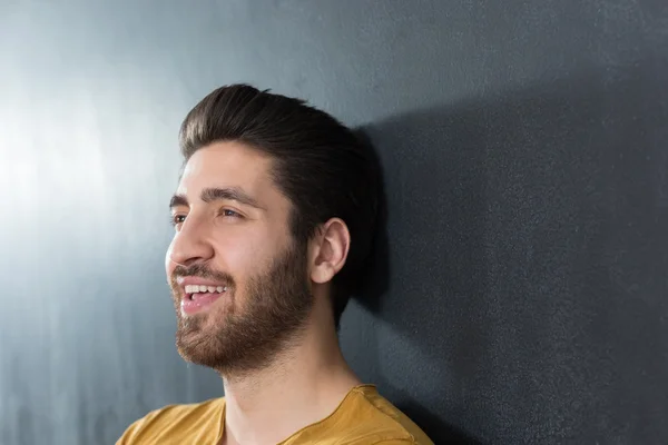 Sexy man with beard smiling big against wall — Stock Photo, Image