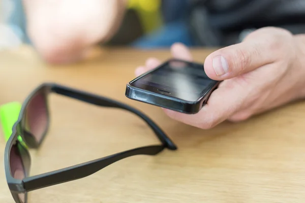 Primer plano de las manos del hombre utilizando el teléfono inteligente con pantalla en blanco — Foto de Stock