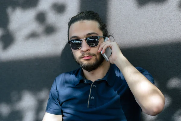 Retrato de um jovem com barba a falar ao telemóvel — Fotografia de Stock